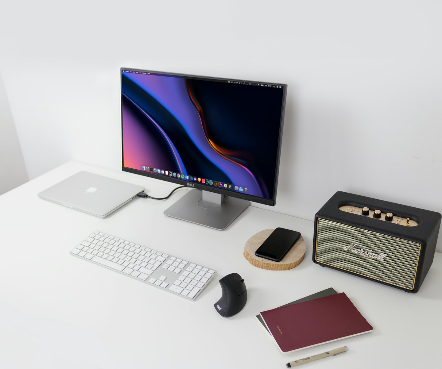 Escritorio moderno con portátil, monitor, teclado y altavoz.